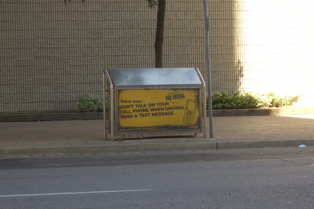 Photo: information notice. Text reads: "Steve says: Don't talk on your cell phone when driving. Send a text message."