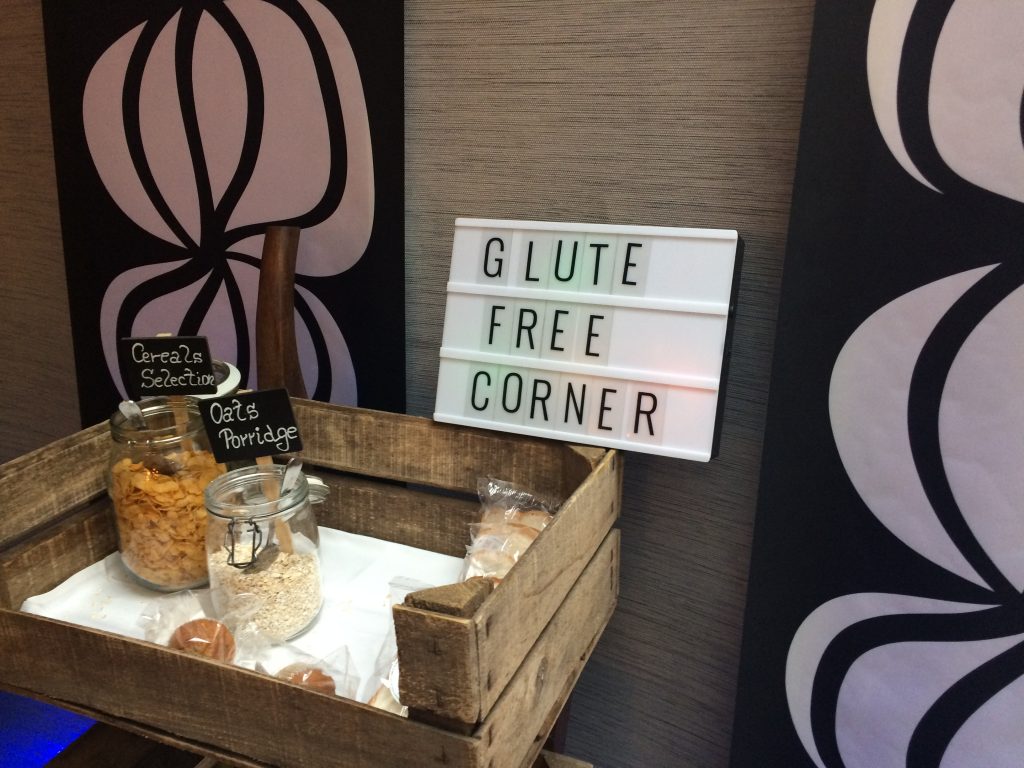 Photo: a sign, saying "glute free corner". That should be "gluten"...